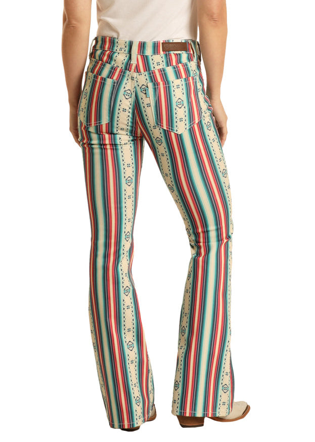 Woman wearing a white t-shirt and colorful striped pants with a cowboy hat on a white background