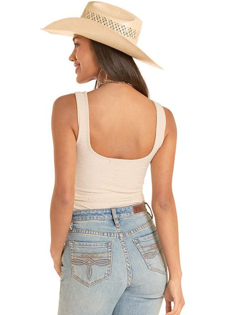 Woman wearing light blue jeans and a beige hat on a white background