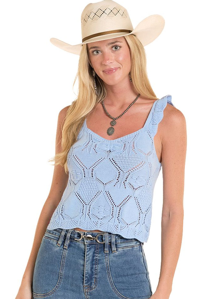 Woman wearing a light blue tank top and jeans with a cowboy hat on a white background