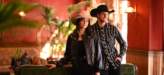 Man and woman in cowboy hats posing in a stylish interior setting