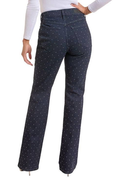 Woman wearing dark wash boot cut studded jeans. 