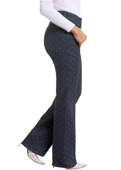 The side of a woman wearing dark wash studded bootcut jeans. 