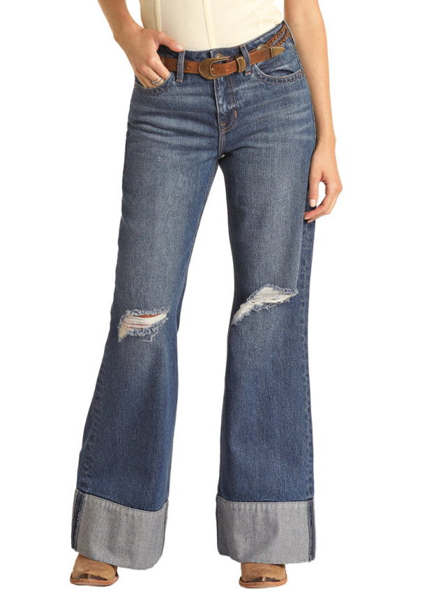 Distressed blue jeans worn by a person on a white background