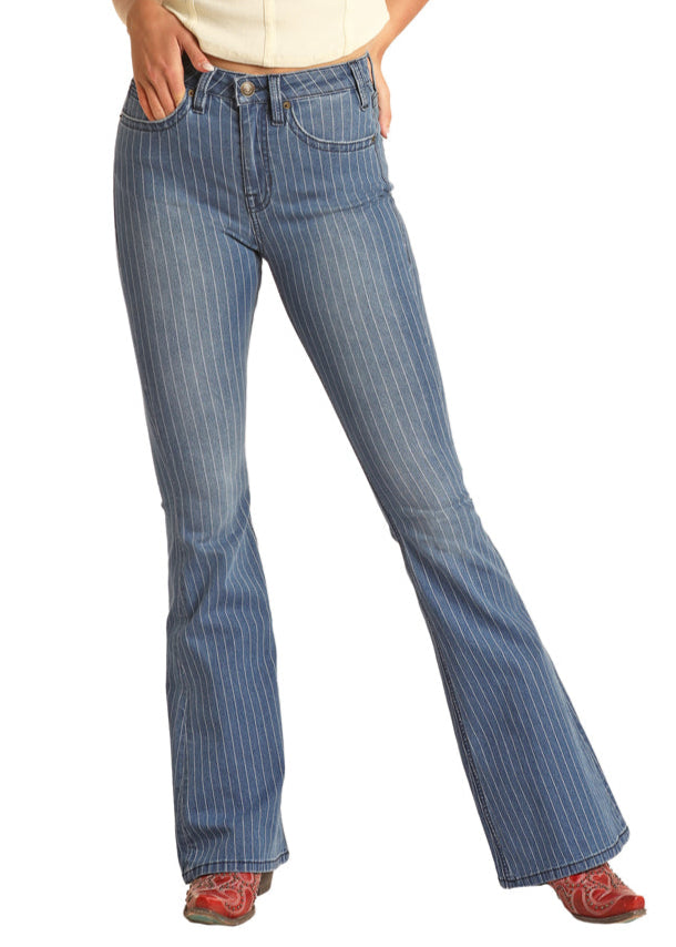 A person models Rock & Roll Denim's Stripped Blue Button Flare Jeans, standing with one hand on their hip and legs slightly apart. Their upper body is mostly out of frame.