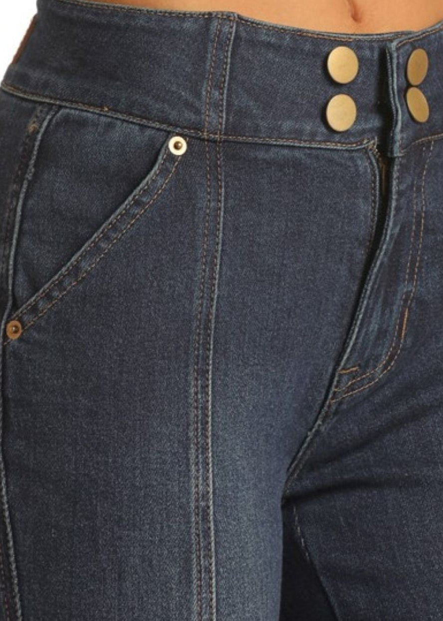Close-up of dark blue jeans with gold buttons on a white background