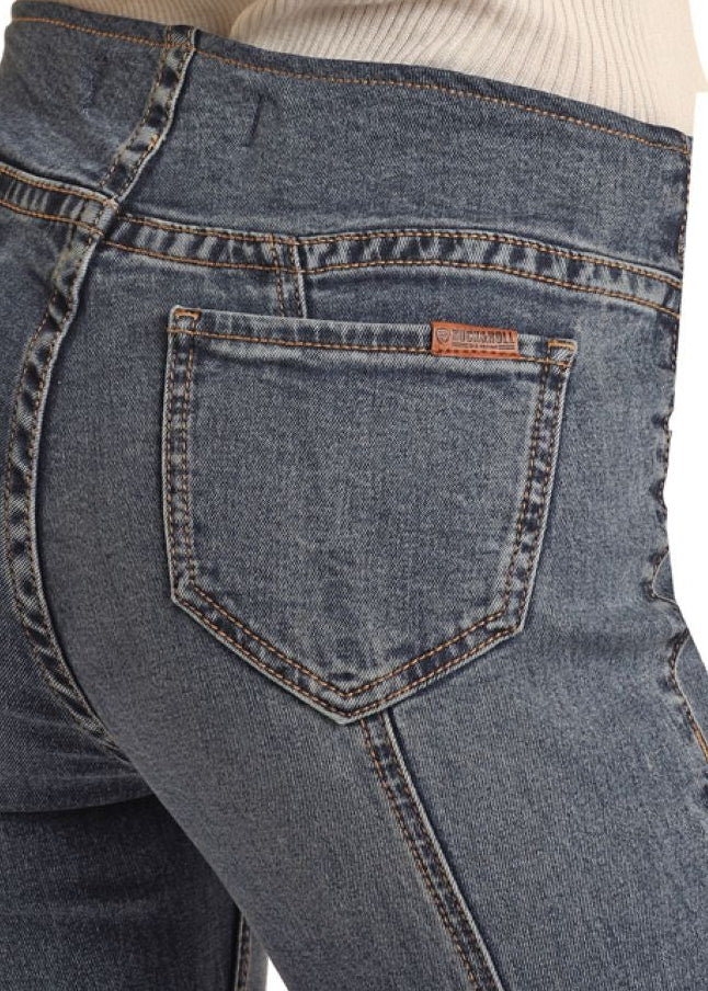 Close-up of blue jeans with a brand logo on the pocket against a white background