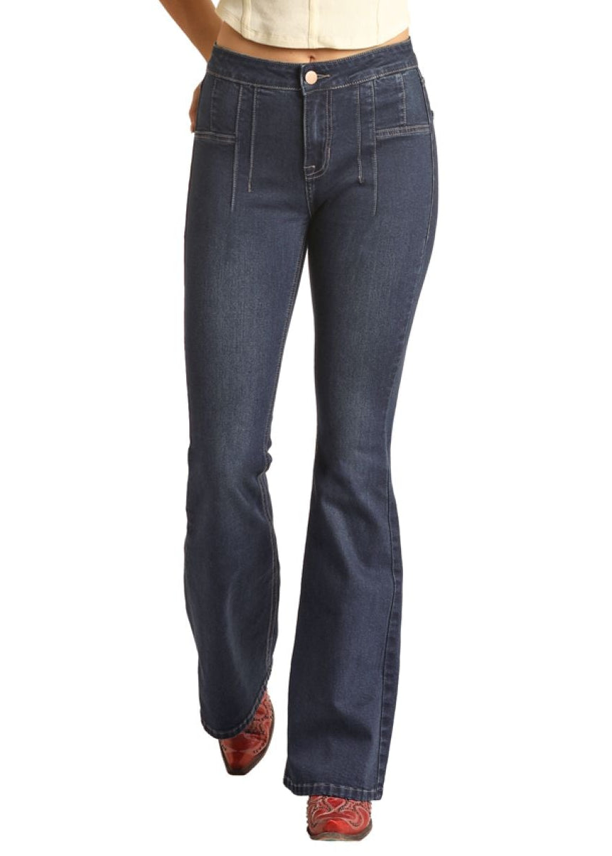 Woman wearing a beige vest, blue jeans, and a cowboy hat on a white background