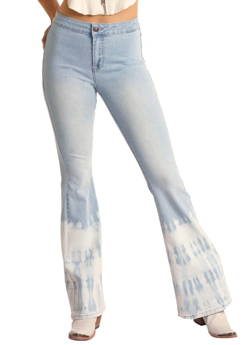 Woman wearing a white tank top, light blue tie-dye jeans, and a straw hat on a white background