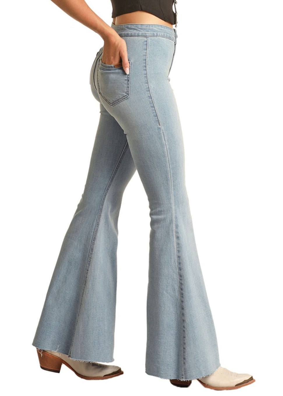 Woman wearing a black crop top and light blue flared jeans with a beige cowboy hat on a white background