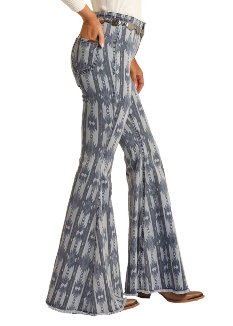 Woman wearing a white long-sleeve top and blue tie-dye flared pants with a cowboy hat on a white background