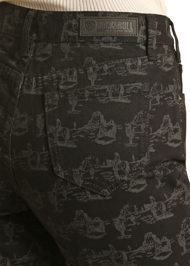 Black patterned pants worn by a person with a beige top on a white background