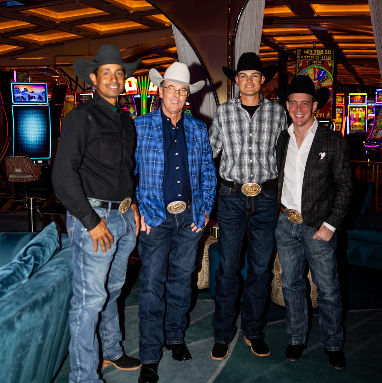 Four men in cowboy hats posing together in a casino setting