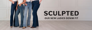 Four models wearing blue denim jeans in different washes and bootcut/flared fits, standing indoors next to large black text that reads 'SCULPTED OUR NEW LADIES DENIM FIT'.
