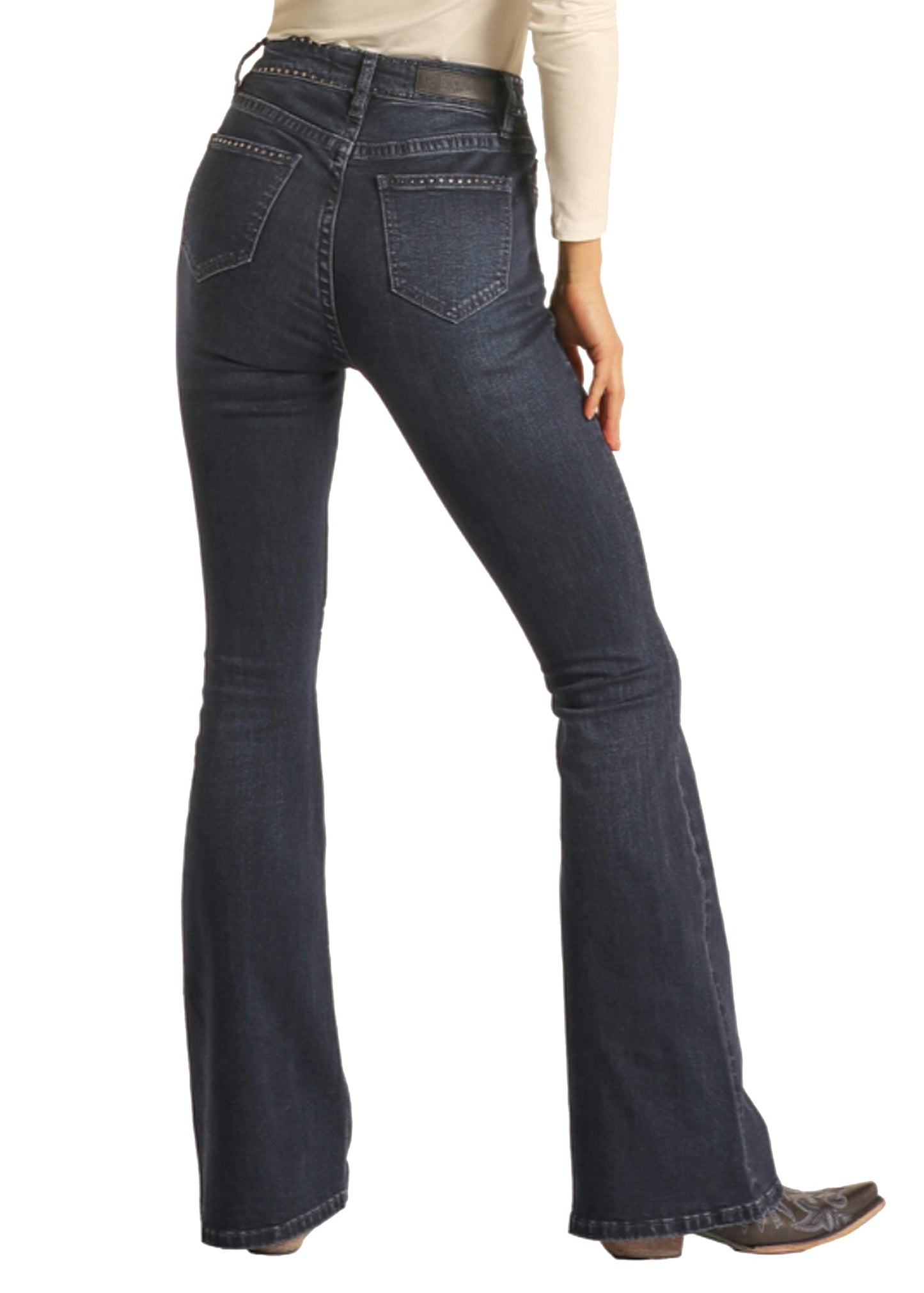 Dark blue flared jeans worn by a person on a white background