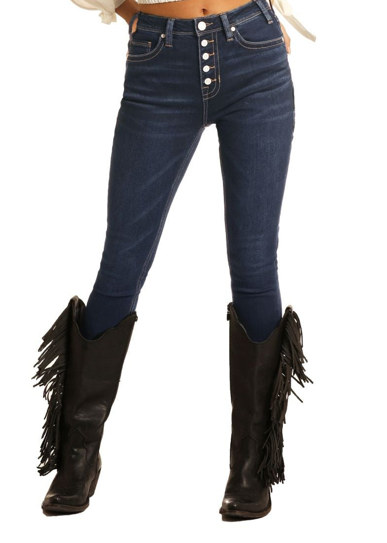 Woman wearing a white long-sleeve top, blue jeans, and black fringed boots on a white background