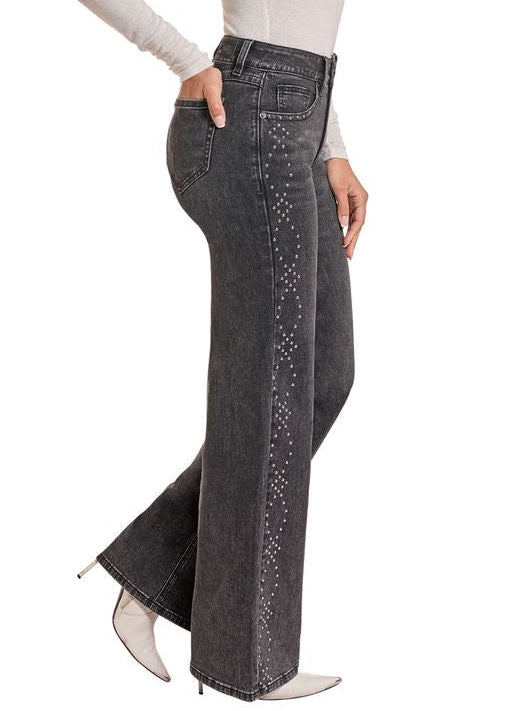 Side view of a woman in a pair of black studded jeans.