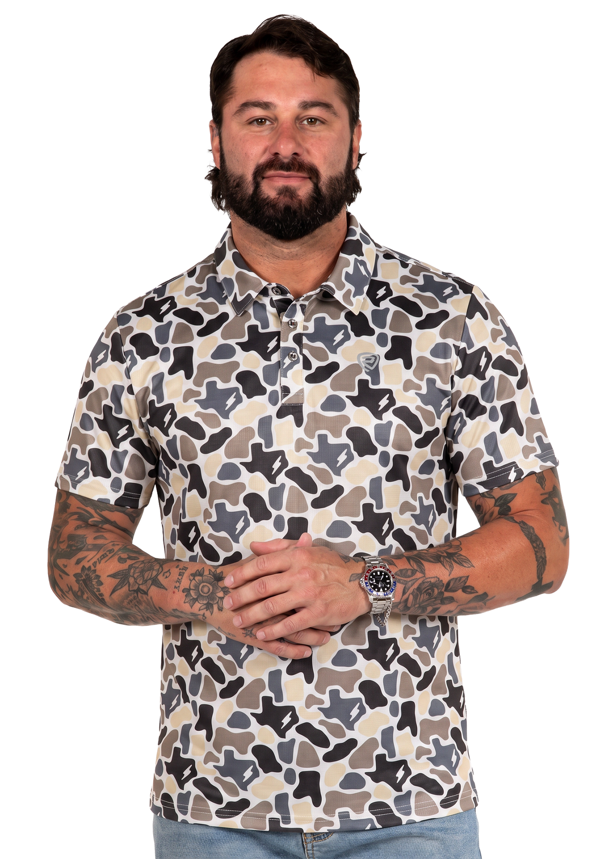 Koe Wetzel wearing a short-sleeve button-up shirt with a beige, brown, and black camouflage pattern, photographed against a plain white background.