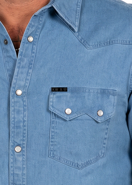 Detail image of a denim pearl snap pocket shirt.