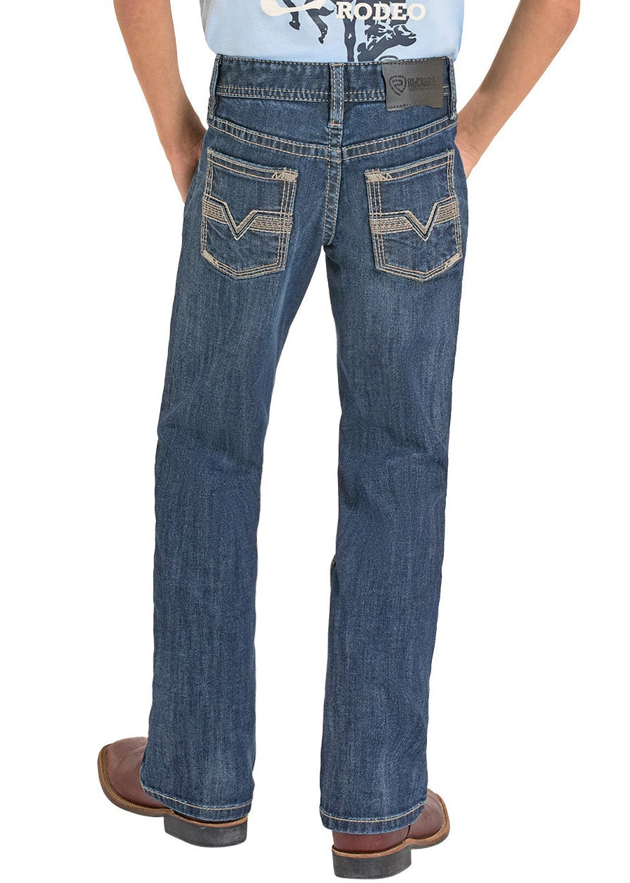 Boy wearing a light blue t-shirt with graphic design and blue jeans, standing against a white background.