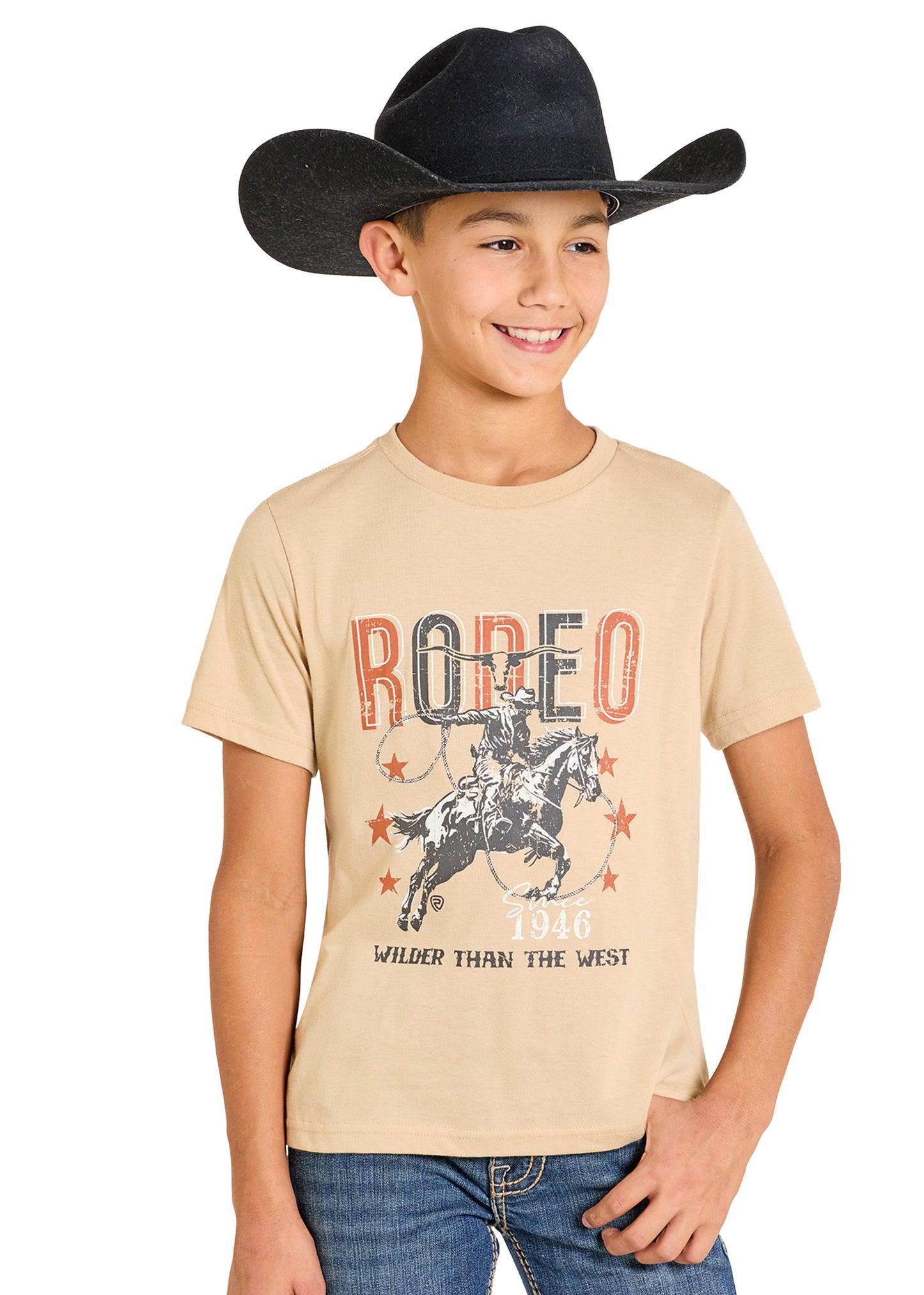 Child wearing a beige t-shirt with a rodeo graphic and text, smiling against a white background.