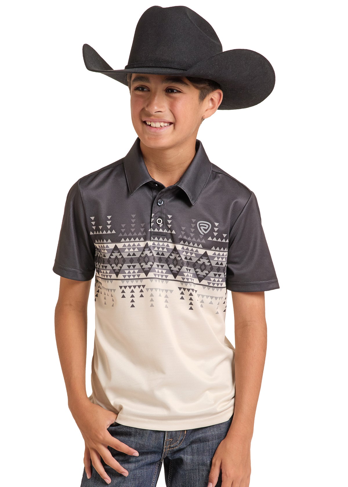 A young boy wearing a black cowboy hat, a dark gray and beige patterned polo shirt, and blue jeans, standing against a solid white background.