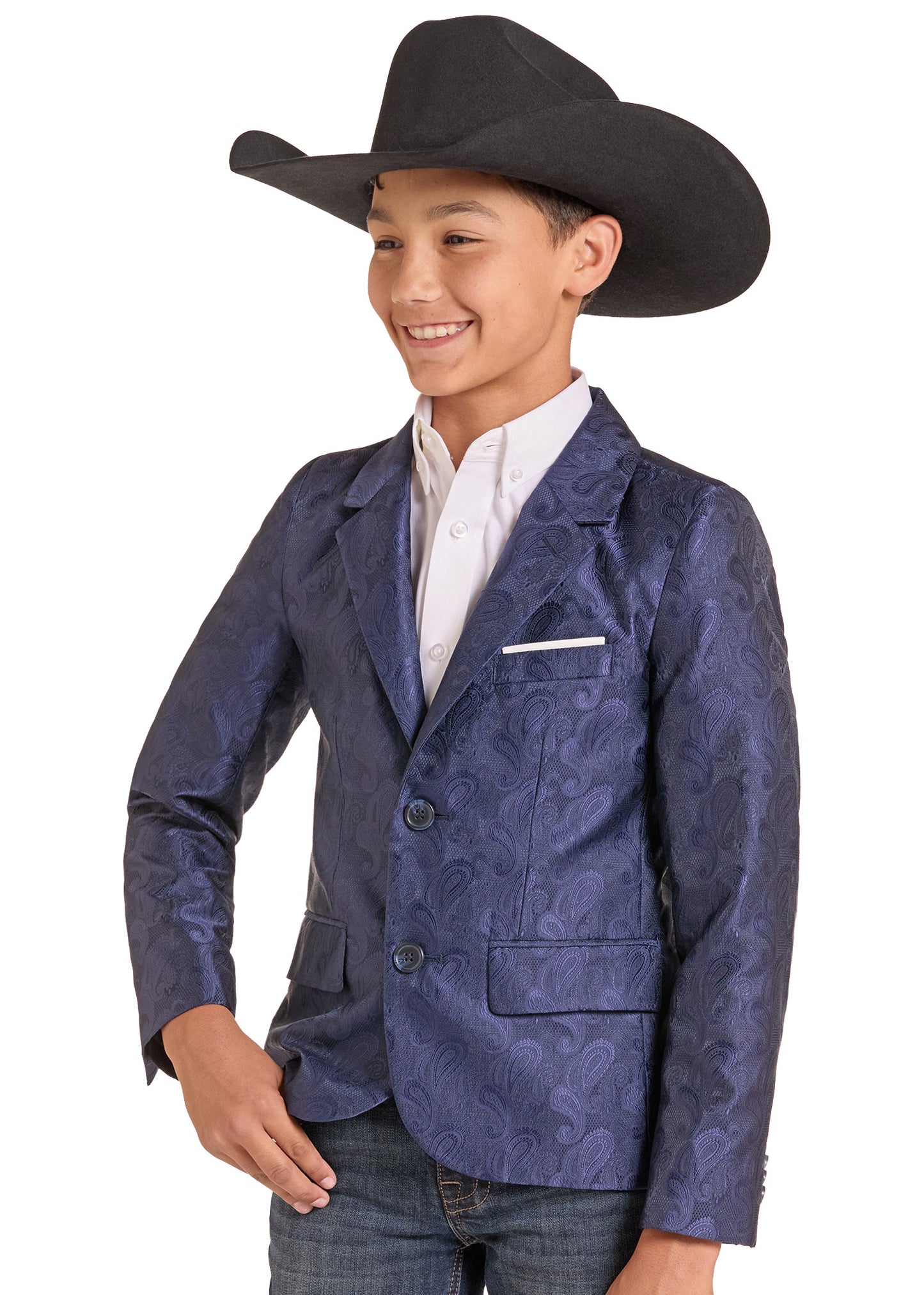 A young boy modeling a navy blue paisley patterned blazer, a white collared shirt, and a black cowboy hat against a white background.