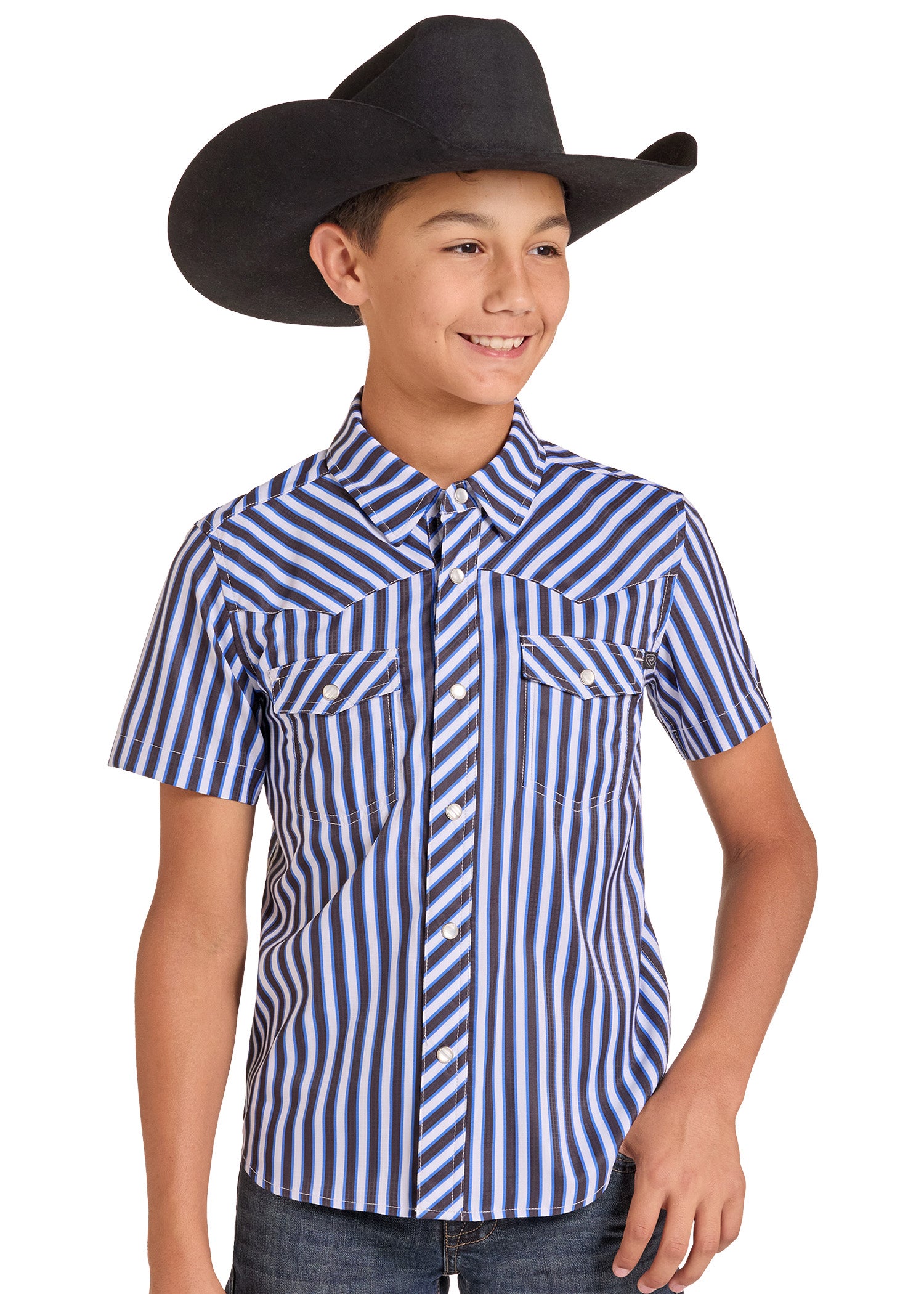 A young boy wearing a blue and white vertically striped short-sleeve western shirt with two chest pockets, paired with a black cowboy hat and dark jeans.