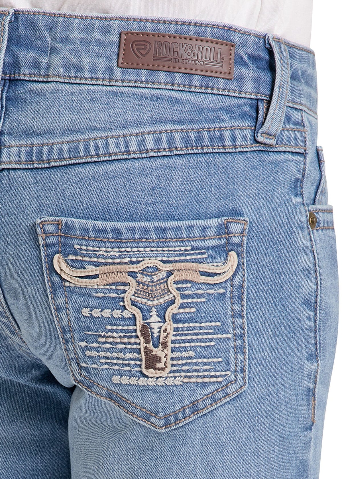 Close-up of the back pocket of light blue denim jeans featuring a large embroidered longhorn steer design on the pocket, with a brown Rockroll brand patch on the waistband.