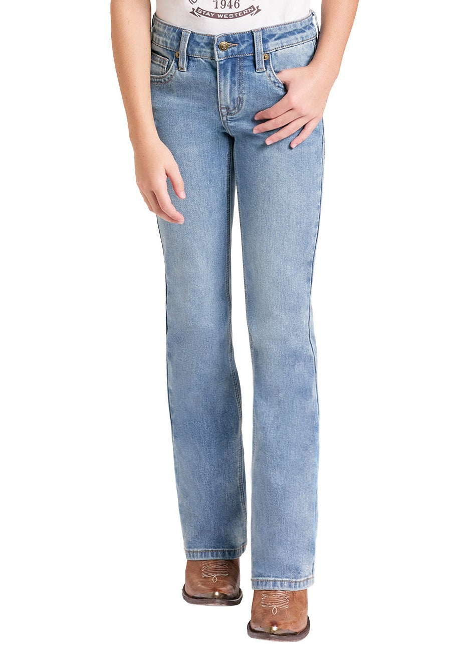 A young girl modeling a western-themed raglan t-shirt with a cowgirl graphic, paired with light-wash blue jeans, a beige cowboy hat, and brown cowboy boots, shown against a plain white background.