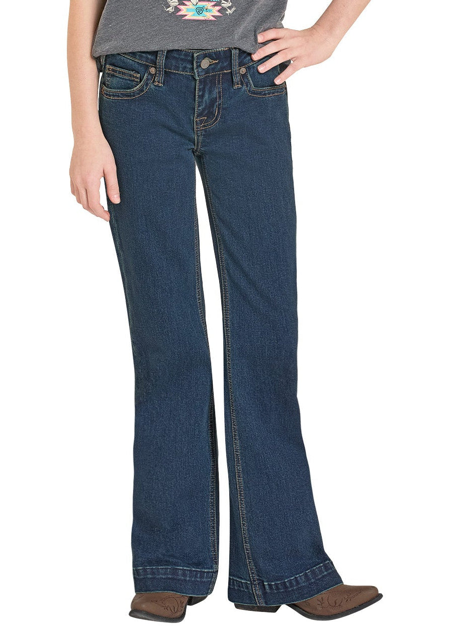 Girl wearing a gray t-shirt with a graphic design and blue jeans on a white background