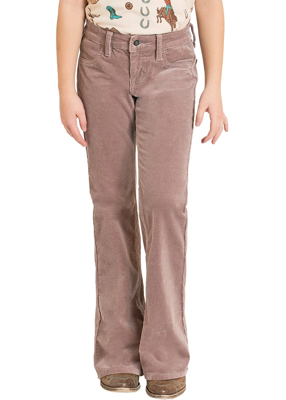 Young girl wearing a cowboy hat, patterned shirt, and brown pants on a white background
