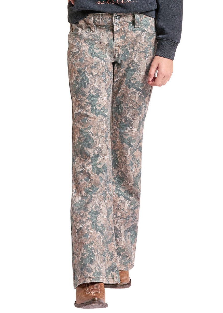 A young girl modeling a dark gray graphic sweatshirt, camouflage pants, and a beige cowboy hat against a plain white background.