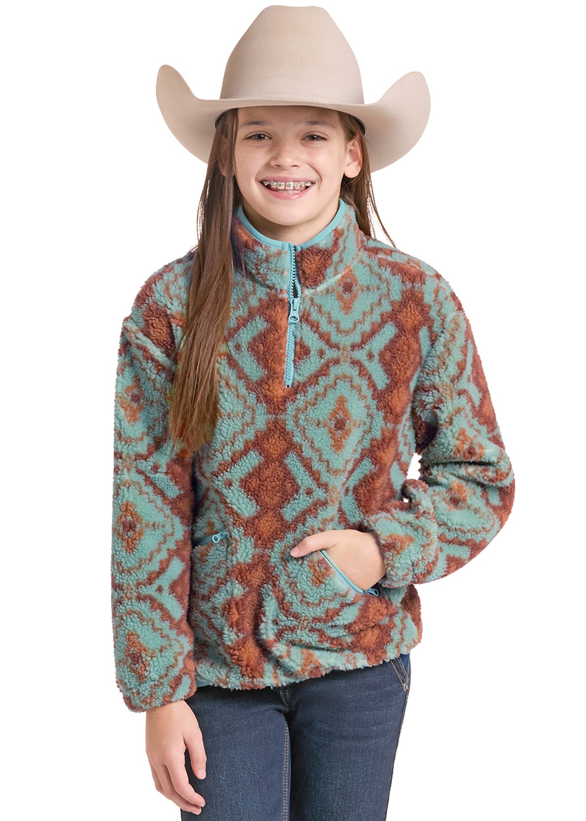 A young girl wearing a beige cowboy hat and a turquoise and rust patterned fleece quarter-zip pullover jacket, paired with blue jeans, against a solid white background.