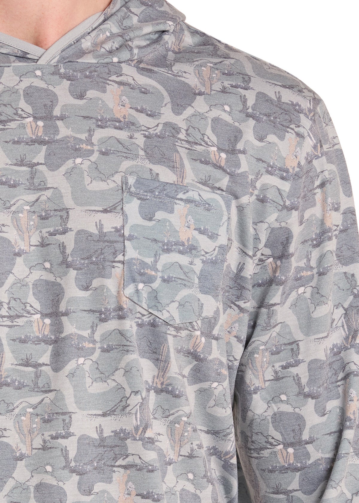 Close-up of a hooded long-sleeve shirt with an all-over abstract landscape print in shades of gray, blue-gray, and beige, featuring a chest pocket.