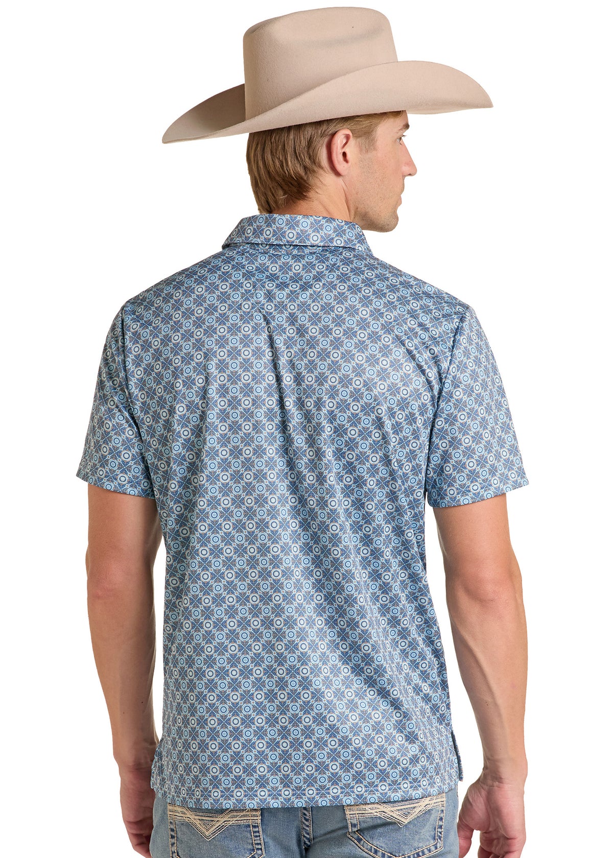 A man wearing a light blue and white geometric patterned short-sleeve button-down shirt, shown from the back. He is also wearing a beige cowboy hat and light-wash jeans, photographed against a solid white background.
