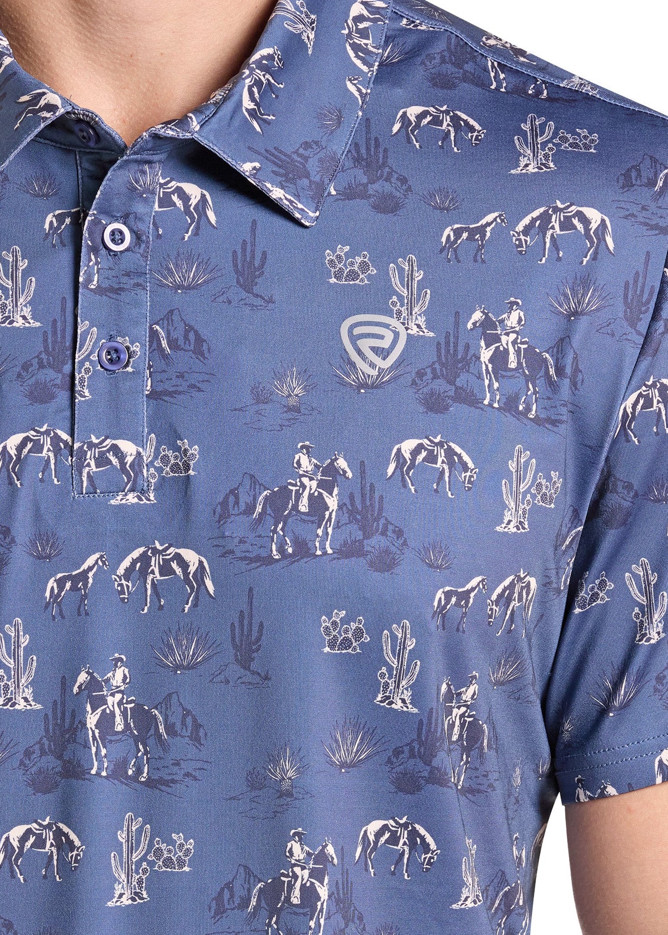 Close-up of a blue short-sleeve polo shirt with a white western-themed print featuring horses, riders, and cacti, worn by a model.