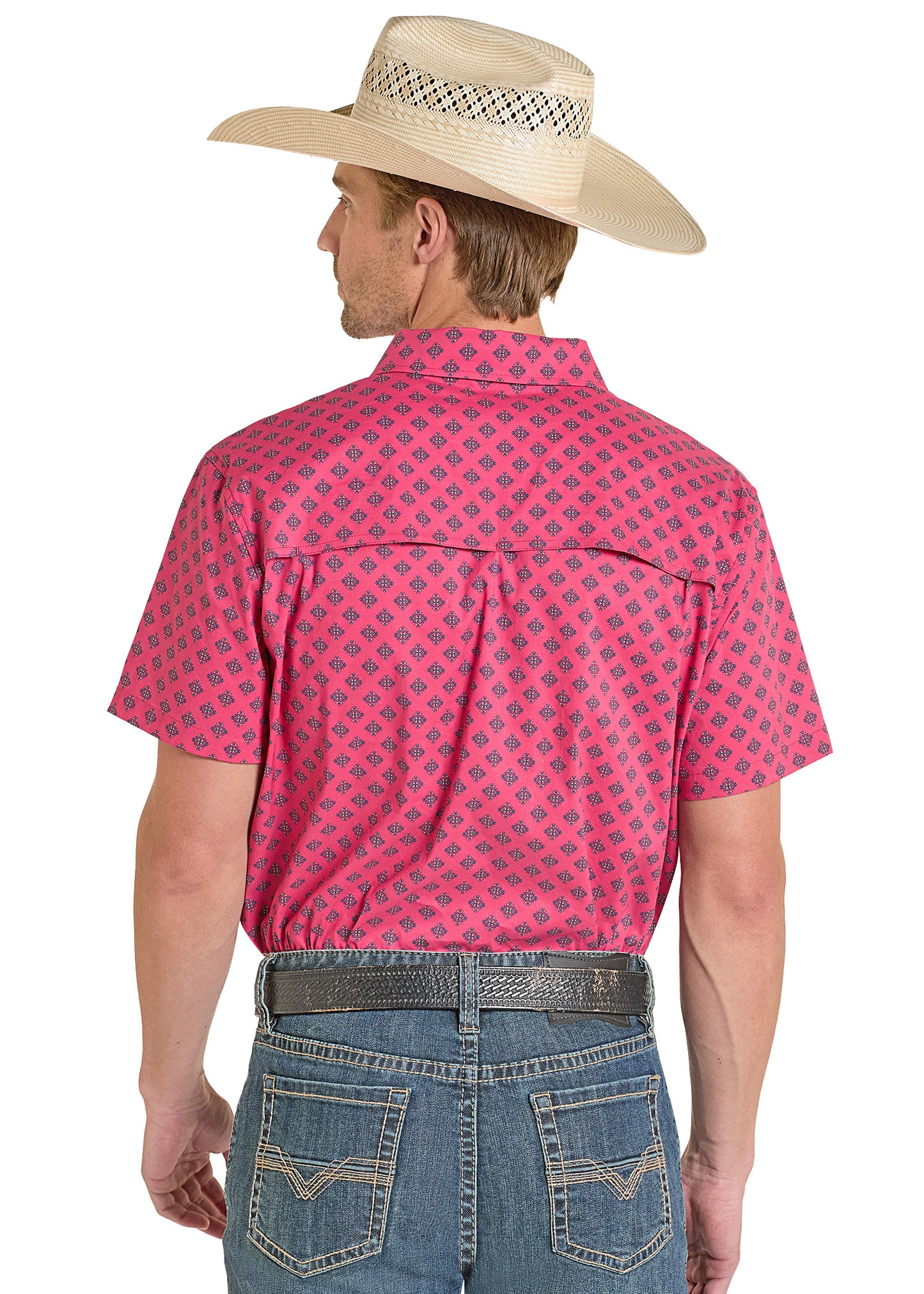 Man wearing a pink patterned shirt, blue jeans, and a beige cowboy hat on a white background