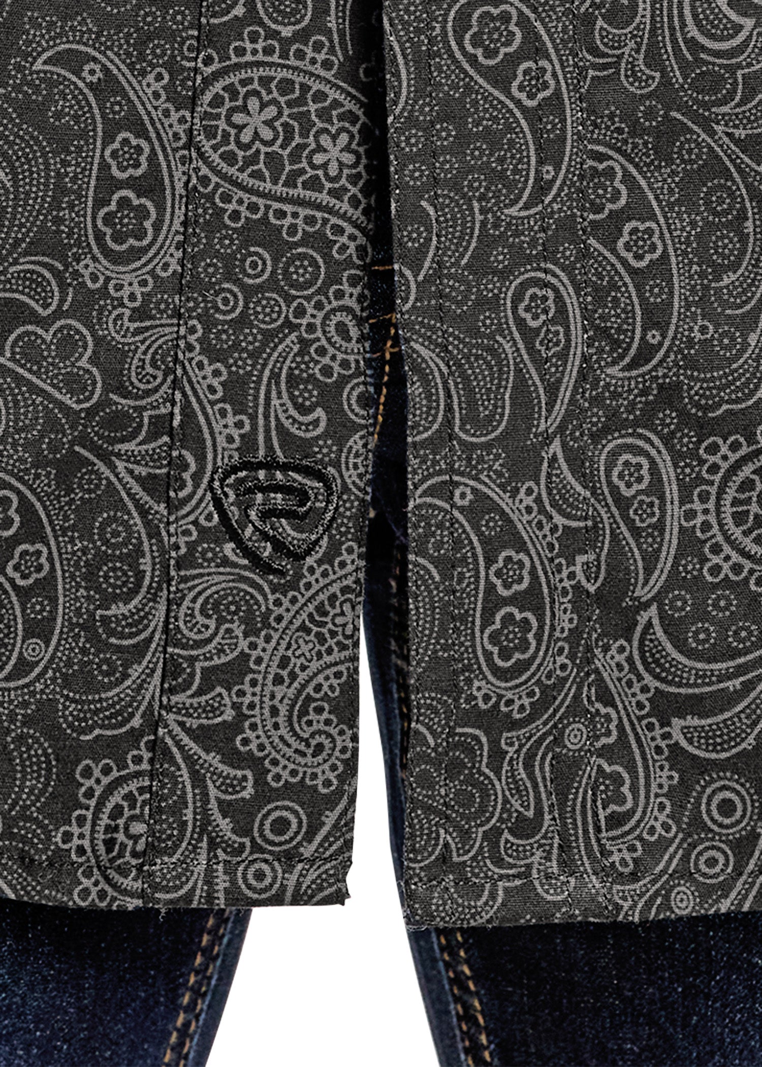 Close-up of a dark fabric with paisley pattern and a brand logo.