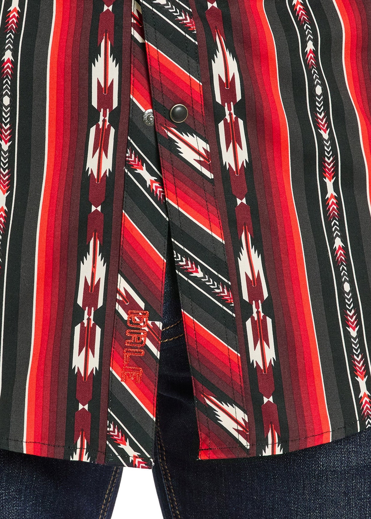 Close-up of a red, black, and white patterned shirt with a button on a white background.