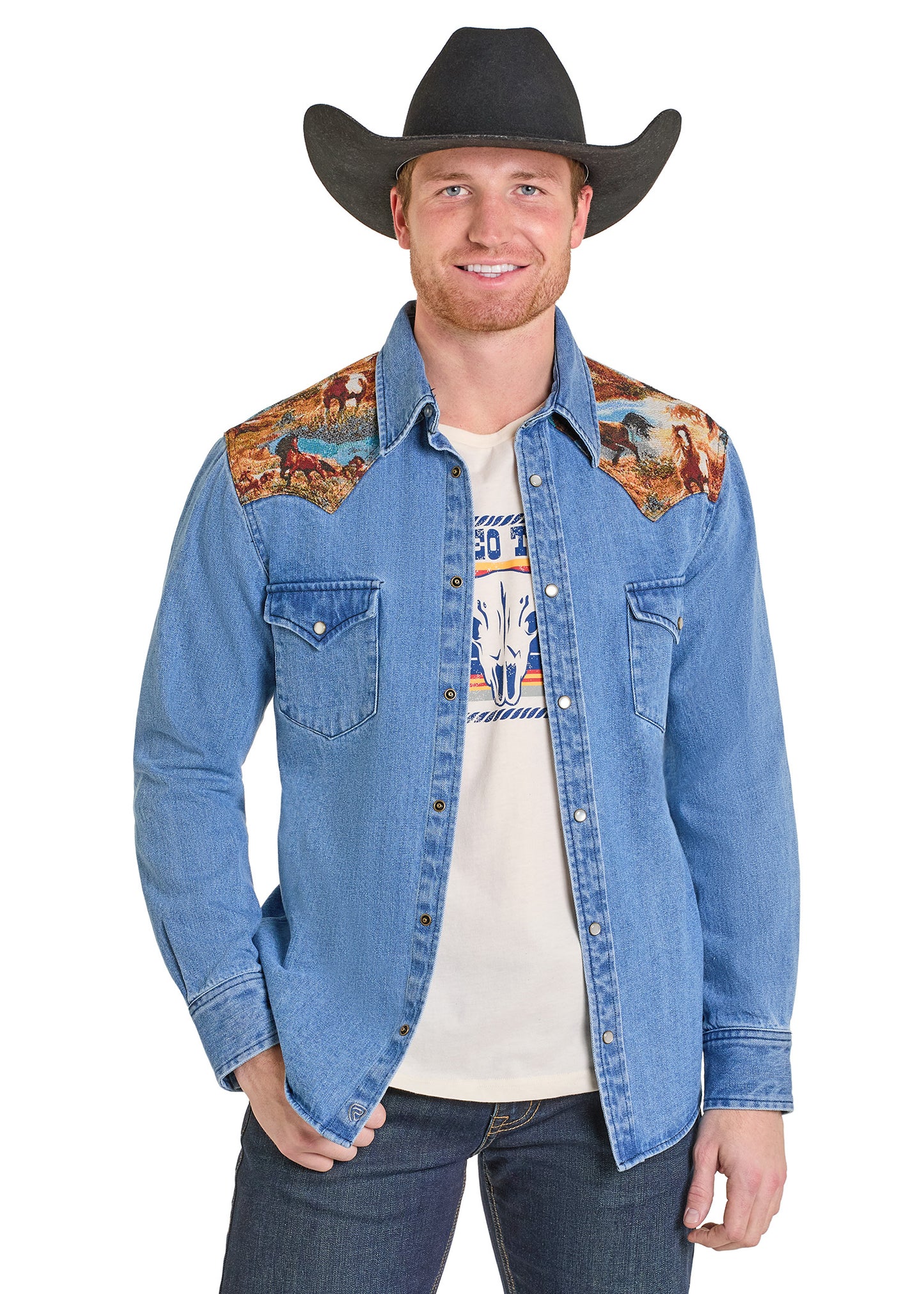 Man wearing a denim jacket with embroidered shoulder panels on a white background