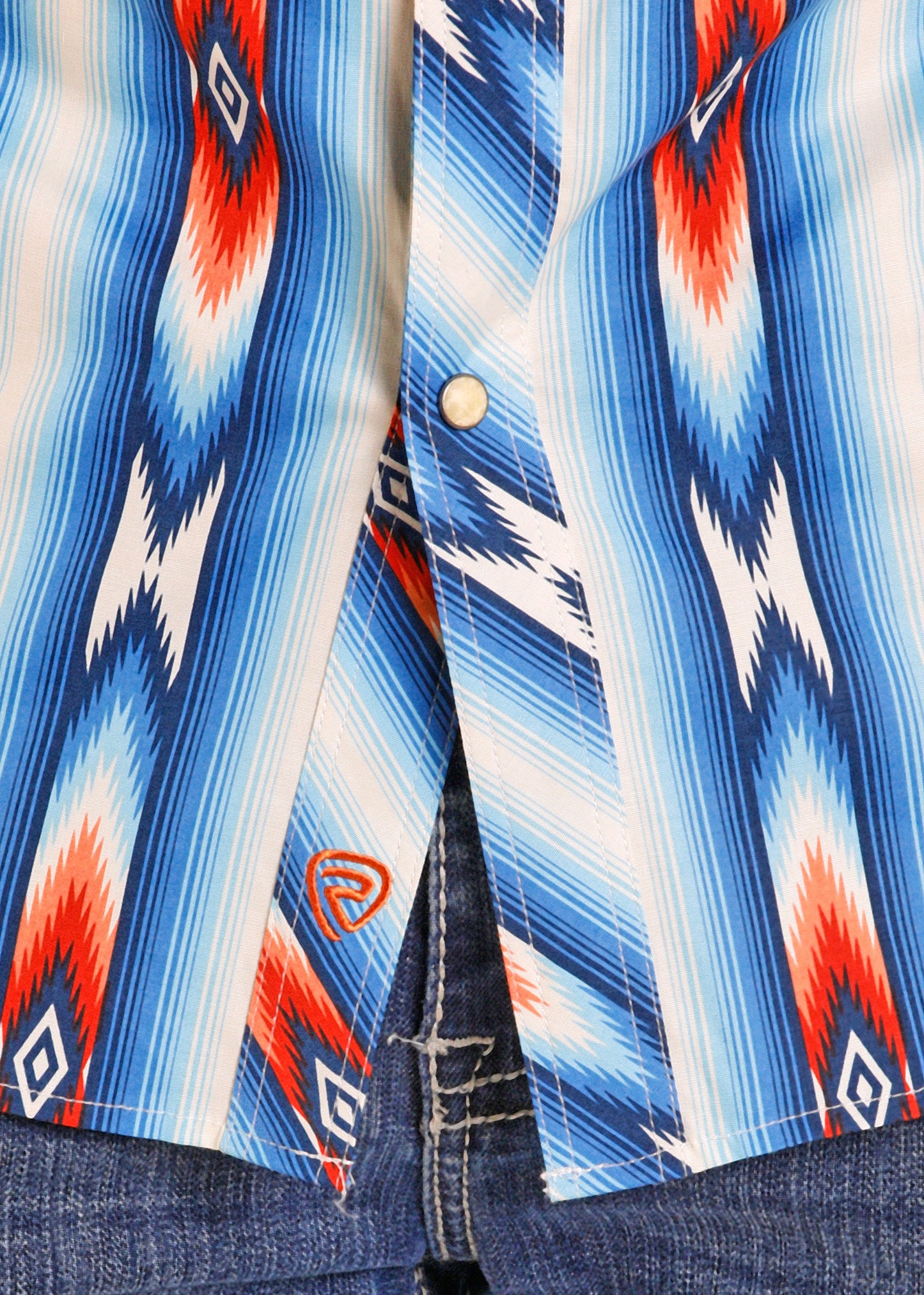 Close-up of a colorful patterned shirt with a Rock & Roll Denim logo on a blue stripe background