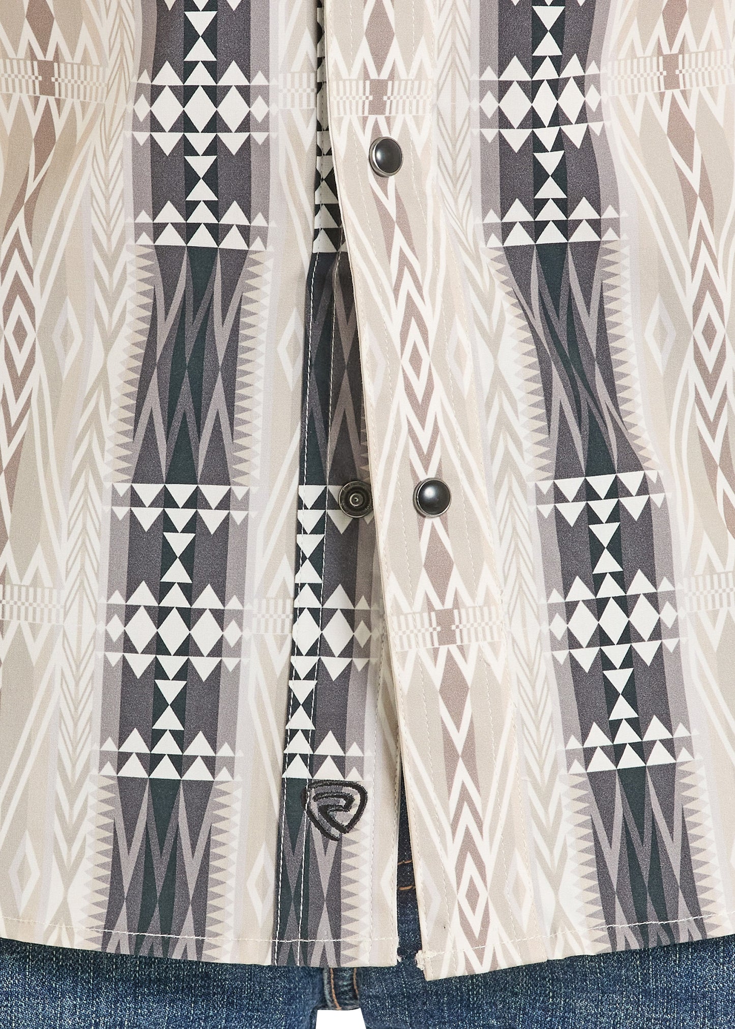 Close-up of a patterned jacket with geometric design on a plain background