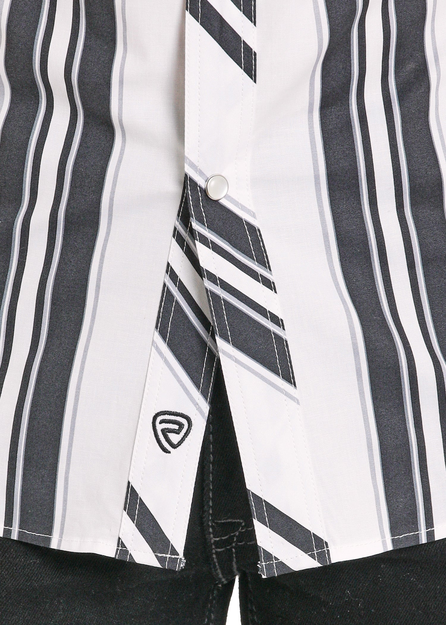 Close-up of a black and white striped shirt with a brand logo on a dark background