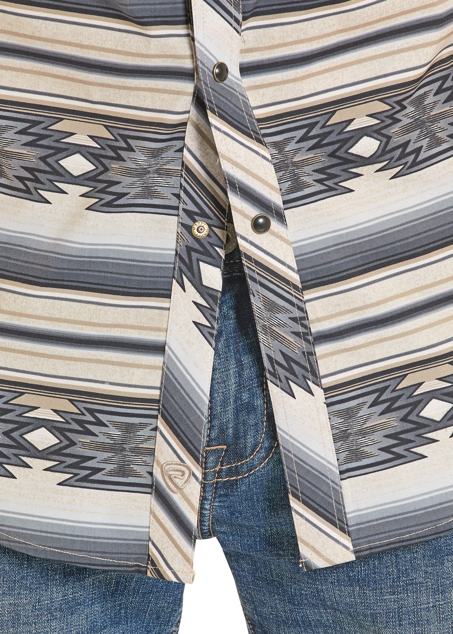 Close-up of a patterned shirt with a geometric design and blue jeans.