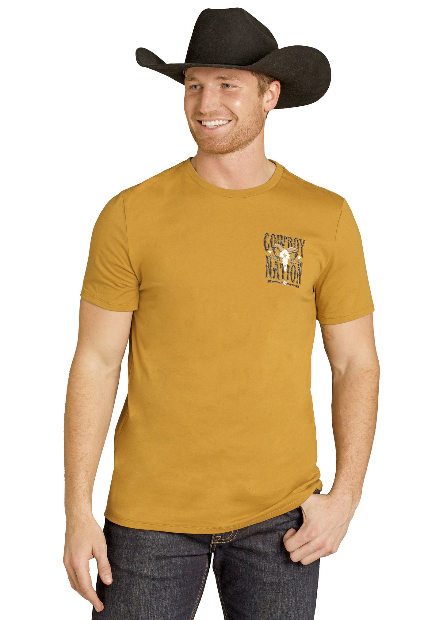 Man wearing a mustard yellow t-shirt with a logo and text, black cowboy hat, and jeans on a white background