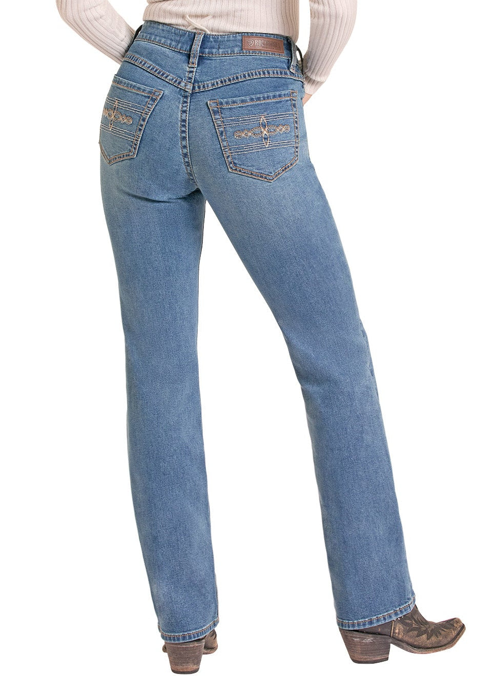 A woman is shown from behind wearing a cream ribbed long-sleeve top with a lace-up back, blue jeans, and a black cowboy hat against a white background.