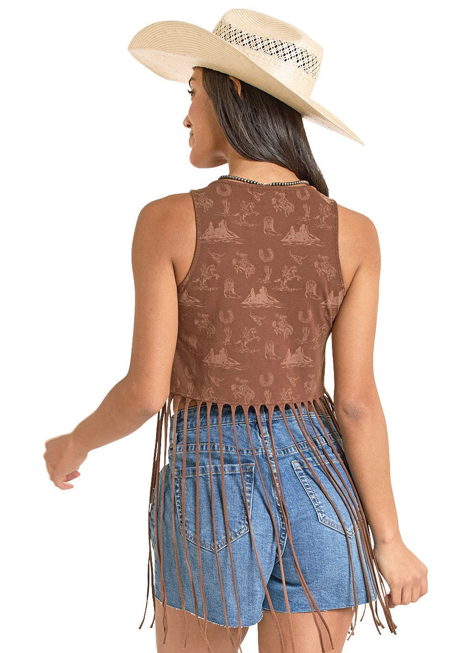 Woman wearing a fringe dress, cowboy boots, and a hat on a white background