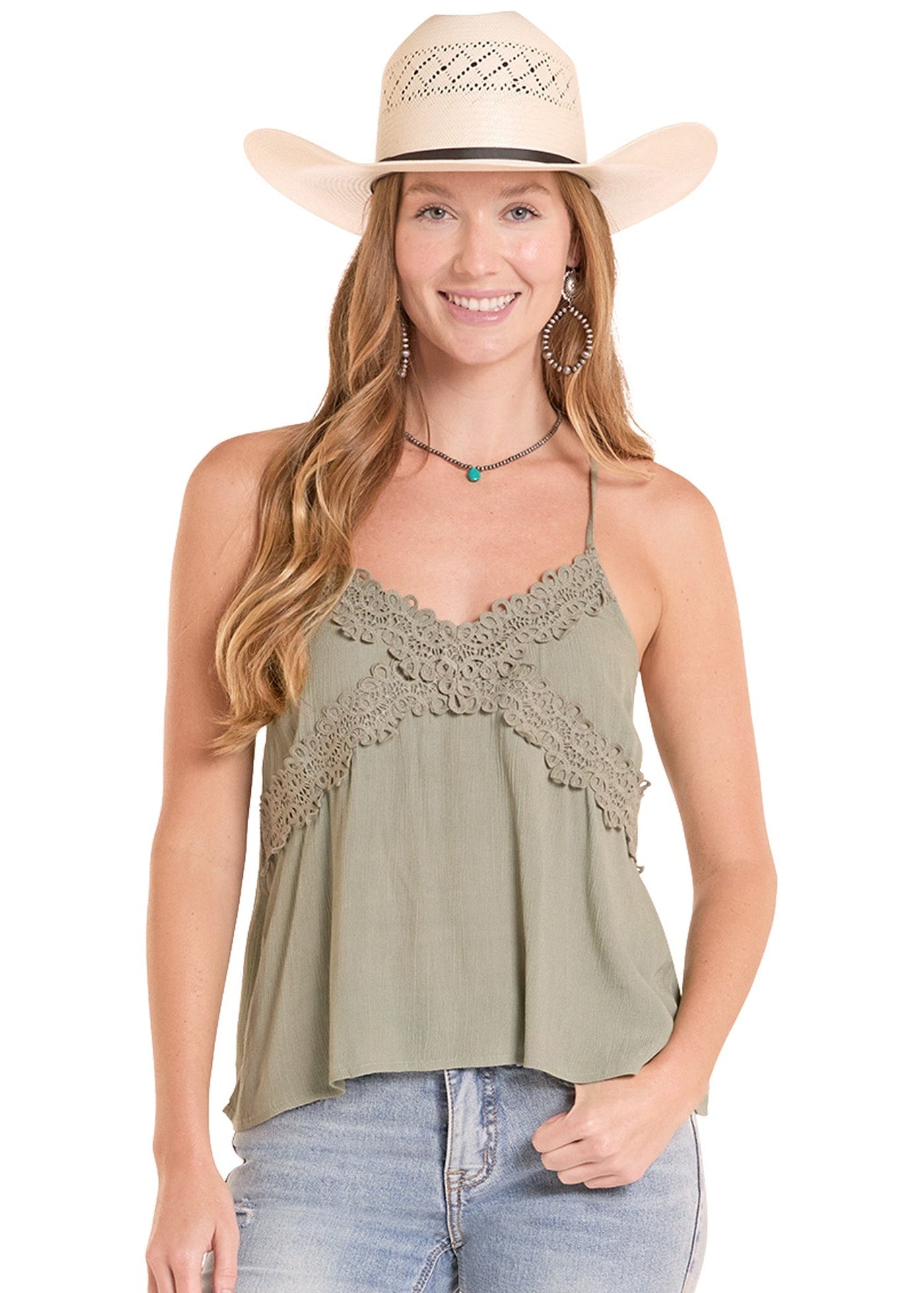 Woman wearing a green lace top and denim jeans with a beige cowboy hat on a white background