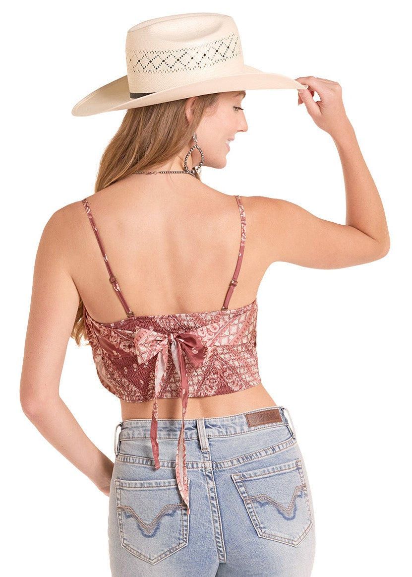 Woman wearing a sequin top and jeans with a cowboy hat on a white background