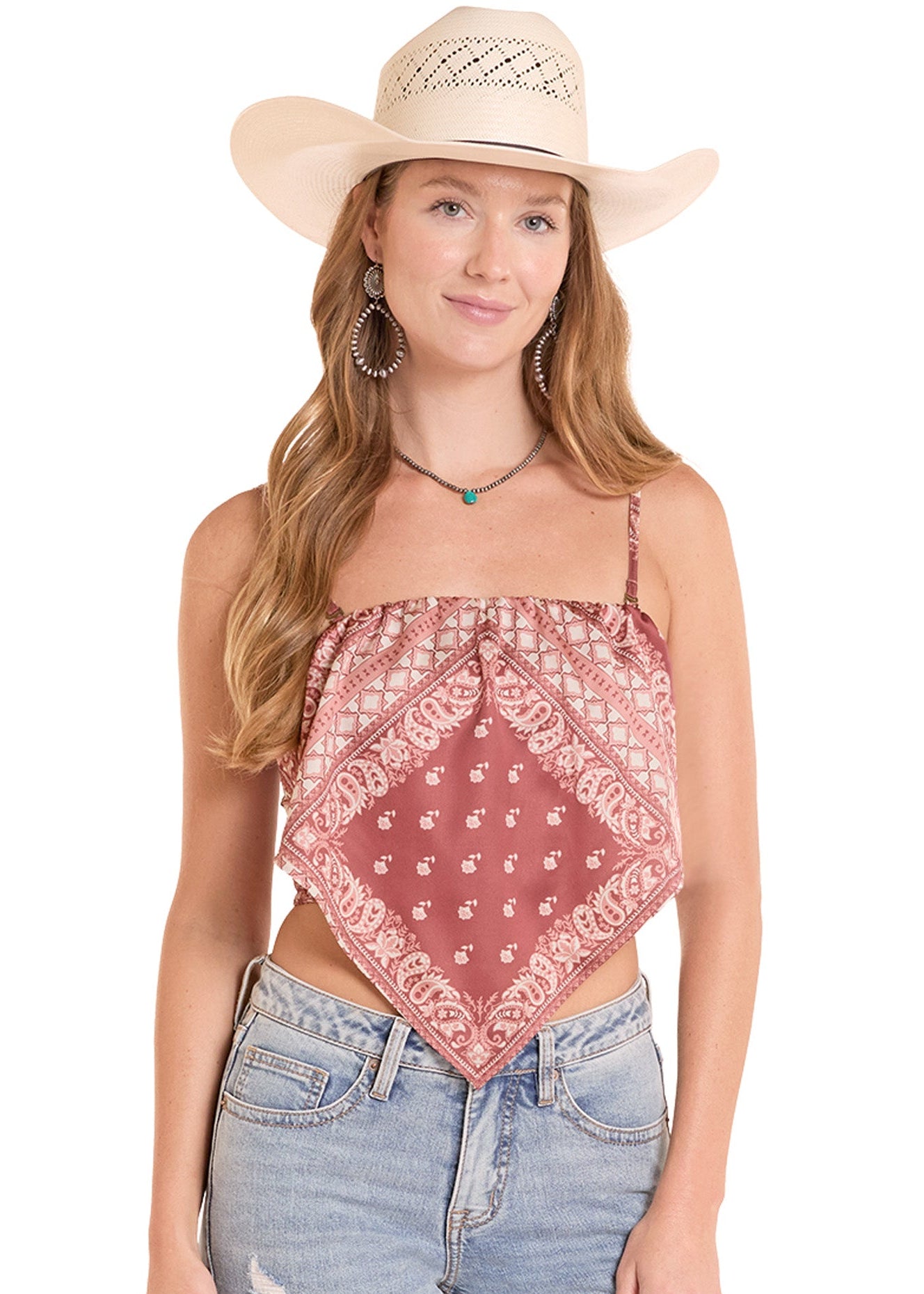 Woman wearing a red bandana top, blue jeans, and a beige cowboy hat on a white background